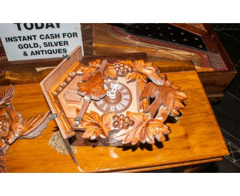 German Black Forest Type Cuckoo Clock with a carved bird top. With two iron cone shaped weights.