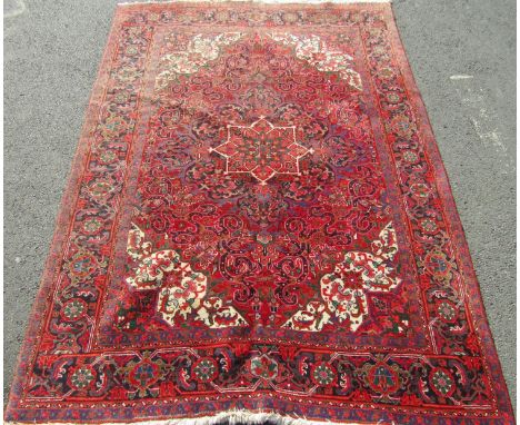 A good quality full pile Hamadan village carpet with scrolled floral and medallion decoration with central ivory panel upon a