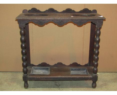 A Victorian Gothic carved oak umbrella/stick stand, with two oval cut out divisions and turned bobbin supports, 76cm wide 