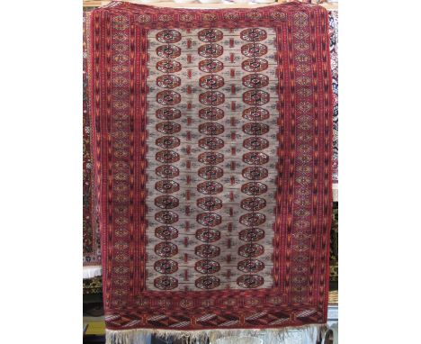 Good quality Bacora rug with central three row geometric medallion design with fawn panel upon a red ground, 180 x 130 cm 