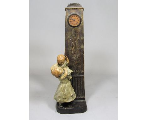 Austrian figural ceramic clock in the form of a mother holding a child beneath a tall Grandfather type time piece, with small