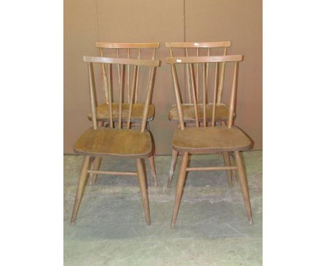 Four Ercol light elm and beechwood dining chairs with tapered stick backs and supports, united by high stretchers (af) 