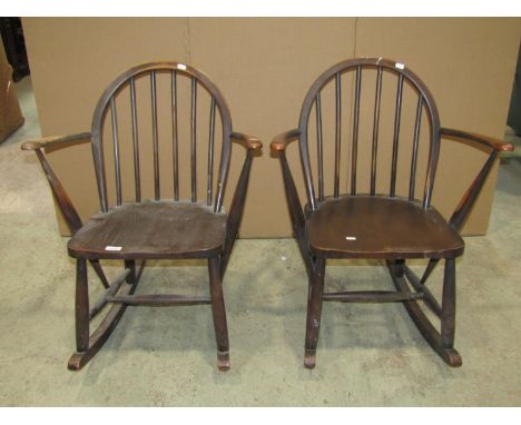 A pair of vintage Ercol stained elm and beechwood hoop and stick back low child's size rocking chairs with open arms 