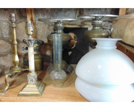 A collection of lighting including two brass column oil lamps with milk white glass shades, a further Edwardian brass table l