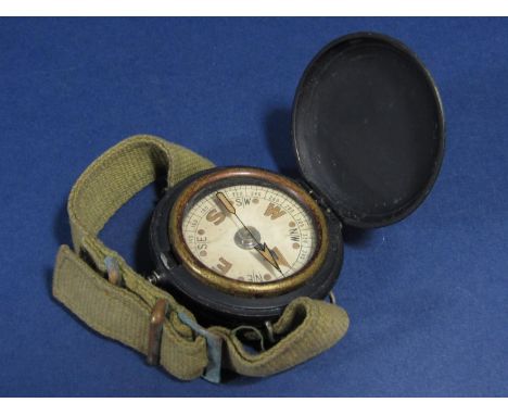 Ebonised military pocket compass, in a hunter type framework and canvas wrist strap, 46 mm case 