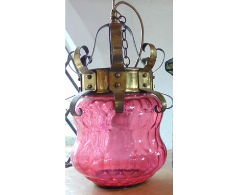 Early 20th century celling light/shade, the brass framework with scrolled detail enclosing a waisted glass shade in cranberry