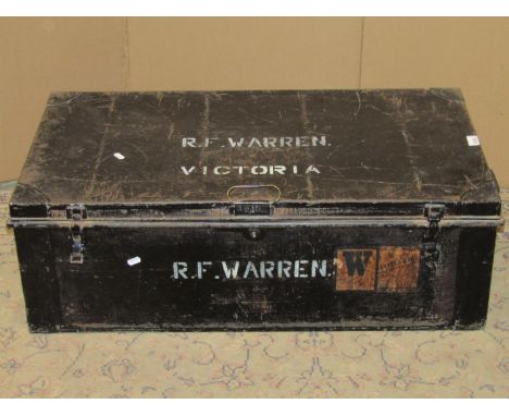 A vintage japanned tin trunk, possibly military related, with painted lettering RF Warren Victoria, containing a pair of hang