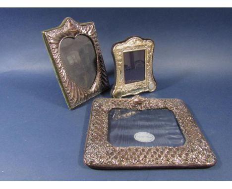 Three silver applied easel picture frames, one with diaper decoration, the other with lobed fluted decoration and another wit