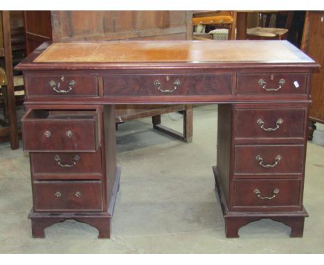 A reproduction Georgian style mahogany veneered kneehole twin pedestal writing desk with inset leather top over an arrangemen