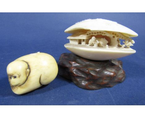 Chinese carved ivory clam, decorated with figures in an exterior scene upon an organic wooden plinth base, 5.5cm high, togeth