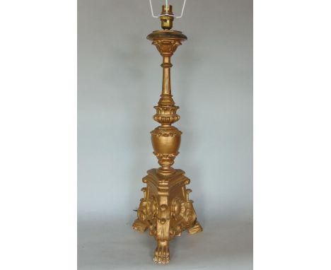 A gilt wood and gesso floorstanding lamp, with triform plateau, carved with flowerhead and paw foot detail, 60cm high 