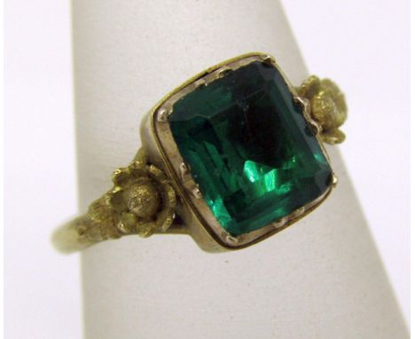 Yellow metal green paste ring in closed back setting, with floral applied shoulders, size K/L, 2.7g 