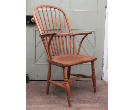 An antique comb back Windsor elbow chair principally in elm, ash and beech on turned supports 
