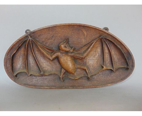 An unusual Victorian carved oak panel showing a bat, wings outstretched beneath a crescent moon, signed to reverse J H Stockt