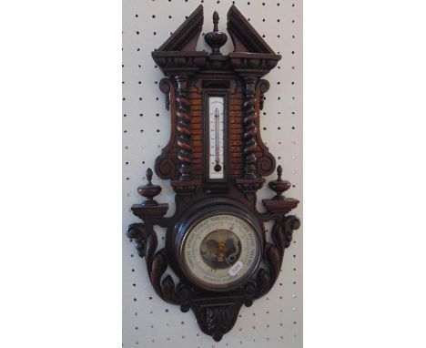 Aneroid barometer win a carved softwood frame with spiral twist, acanthus and turned finial detail 