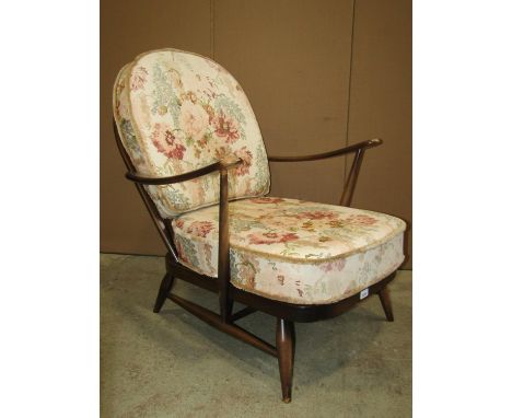 An Ercol dark stained beechwood Windsor style low open armchair with strap work seat and loose cushions, together with one ot