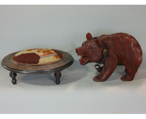 A footstool of oval form with hand worked tapestry panel showing a terrier and a carved wood bear 