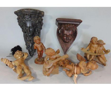 A Victorian carved oak wall bracket in the form of a cherub, with folded wings and floral garlands and a further plaster work