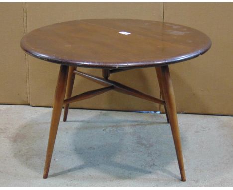 An Ercol stained elm and beechwood single oval drop leaf occasional table raised on simple turned tapered legs united by stre