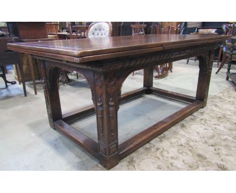 An oak draw leaf dining table with applied Jacobean style mouldings, raised on square cut supports, united by a stretcher sur