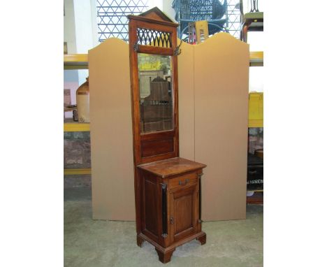 A reproduction hardwood hall stand with architectural detail and rectangular bevelled edge mirror panelled back over a frieze