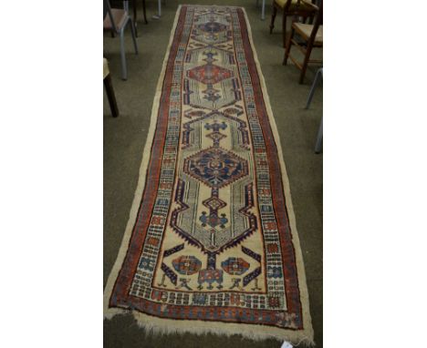 Sarab runner, Iranian Azerbaijan, the pale camel field with a column of stepped lozenge medallions enclosed by ivory and poly