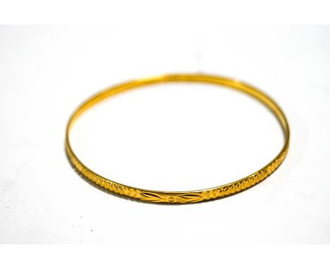 A 22 carat gold bangle, with diamond cut decoration, 3mm wide, internal diameter 6.3 cm, 12.9 g gross