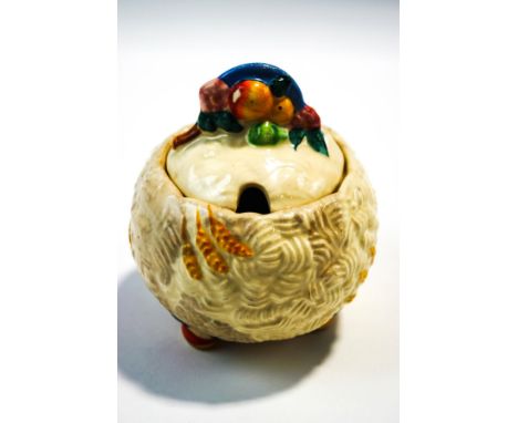 A Clarice Cliff Newport Pottery jam pot and cover, of globe form with harvest decoration, 11.5cm high