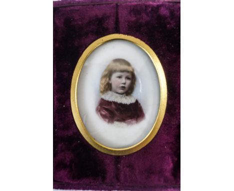 A Victorian portrait miniature of a young girl, hand painted over a base printed on bisque, within a velvet case