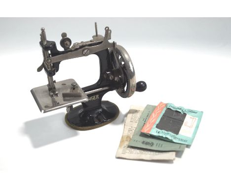 A Victorian child's Singer sewing machine, No.20, with instruction manual, 17cm high