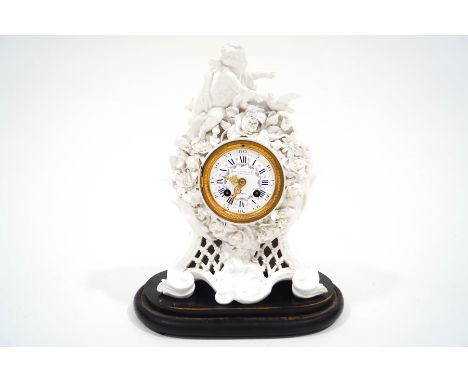 A porcelain mantel clock with white enamel dial signed Howell James & Co. London, the movement striking on a bell, 34cm high,