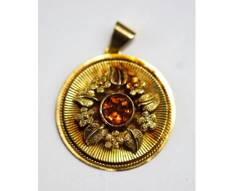 A citrine set pendant, to an disc shaped mount with engine turning and floral decoration, 2.9 cm diameter, 8.6 g gross