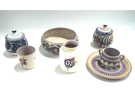 A collection of Poole Pottery with floral and geometric patterns, including two preserve pots and covers, impressed factory m