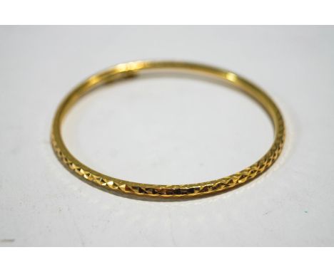 A hinged bangle, stamped '905', with diamond cut decoration, of hollow round section, 3mm wide, internal diameter 5.9 cm, 6.9