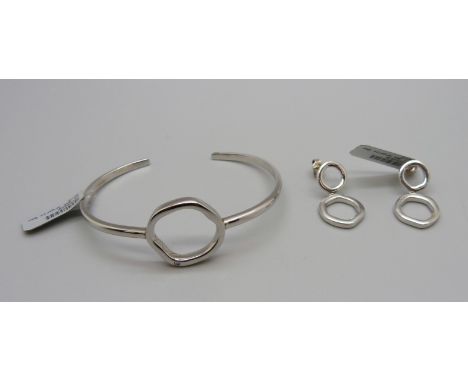 A silver bangle with matching earrings, each set with one small diamond 