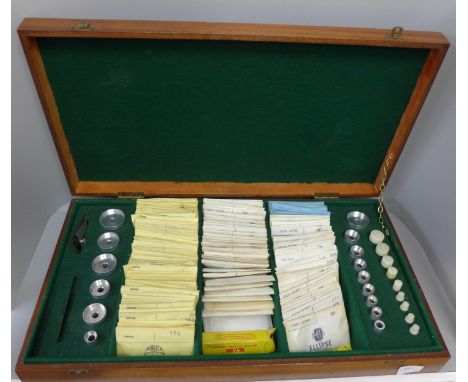 A watchmaker's kit in wooden case containing a large quantity of watch glasses and tools including a watch press 