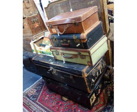 A JAPANNED TIN TRUNK, a canvas travelling trunk and three suitcases