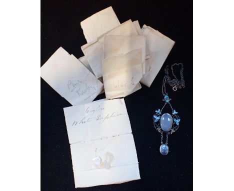 A MOONSTONE AND ENAMEL PENDANT, attached to a fine white metal chain, (broken), together with a collection of un polished sto