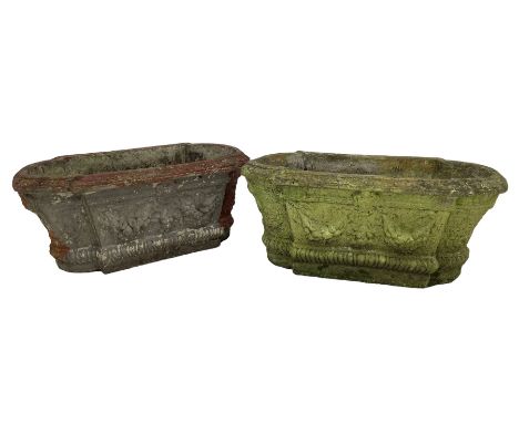 Pair of cast stone garden planters, rectangular form with stepped rounded ends, foliate moulded rim, the body decorated with 