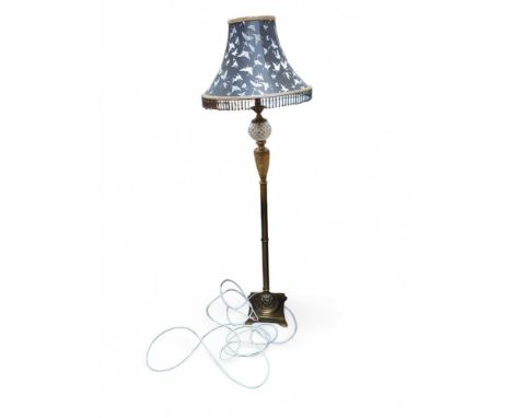 A brass lamp with butterfly-patterned shade. The lamp upon square base with visor-shaped feet at each corner. Glass features,