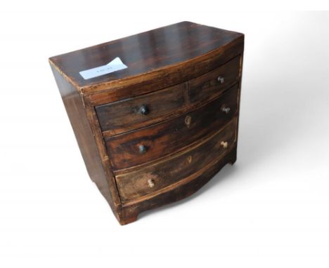 An oak apprentice chest of two short and two long drawers. With turned handles and bracket feet. 28cm tall
