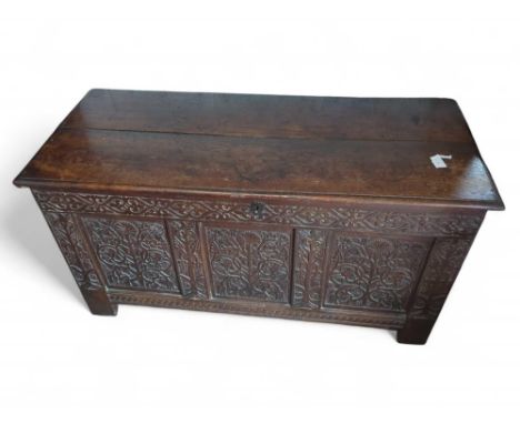 A late-17th/early-18th-century oak coffer with carvings and of panelled form. With winged pegs and hooked hinges and upon str