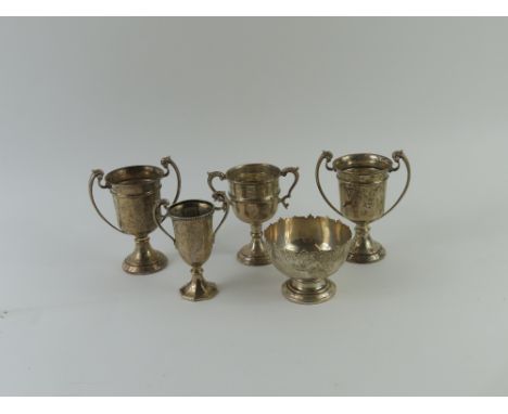 A small collection of mixed silverwares, comprising four various trophy cups and a small presentation bowl, by Goldsmiths and