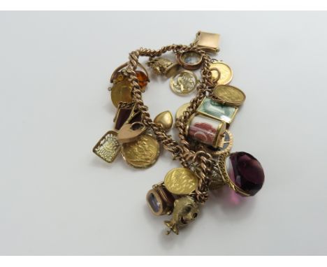 A two row rose gold curb link bracelet, most links marked '375', with various charms attached including a 9ct gold bloodstone