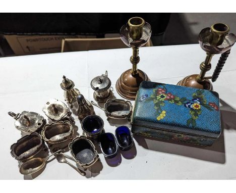 A collection of silver and silver-plated cruet items alongside a pair of brass and copper candlestick holders and a small box