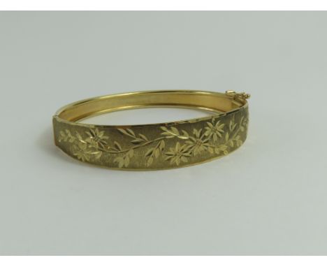 A half engraved bangle, with half engraved diamond cut engraving, marked '375', 9.7g gross