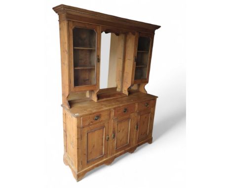A 20th-century pine dresser with central mirror between sets of shelves. The sideboard consisting of three top shelves and th