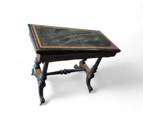 An Edwardian Empire-style card table, with ebonised wood and a walnut inlay running the edge of the folded surface. Two pilla