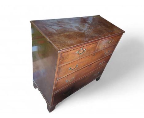 A 20th-century oak chest of two short and three long drawers of increasing size descending, with brass swing handles and upon