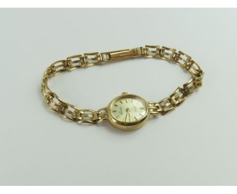 Geneve - a ladies 9ct gold wristwatch, the oval gold dial with gold baton hour markers and hands, on a gate link type bracele